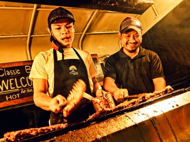 Hua Hin, Thailand, 28th December 2018, All smiles at the super popular BBQ ribs at the jam packed Hua Hin Tamarind night market. clipart