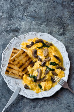 Bir tabak çırpılmış yumurta, mantar ve ıspanak.