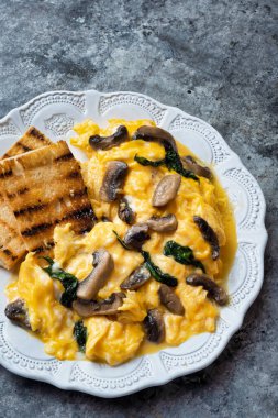 Bir tabak çırpılmış yumurta, mantar ve ıspanak.