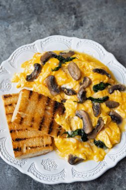 Bir tabak çırpılmış yumurta, mantar ve ıspanak.