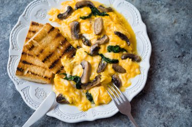 Bir tabak çırpılmış yumurta, mantar ve ıspanak.