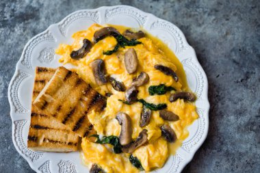 Bir tabak çırpılmış yumurta, mantar ve ıspanak.