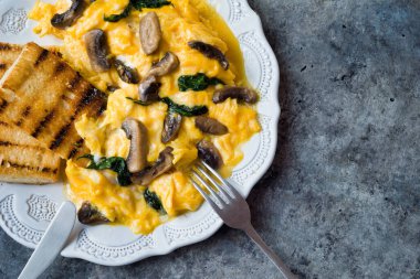 Bir tabak çırpılmış yumurta, mantar ve ıspanak.