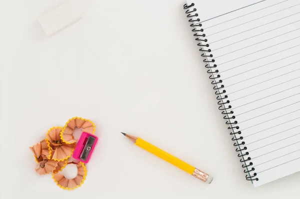 Notebook Com Lápis Borracha Apontador Sobre Fundo Branco — Fotografia de Stock