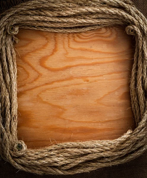 ropes frame with empty wooden surface as background