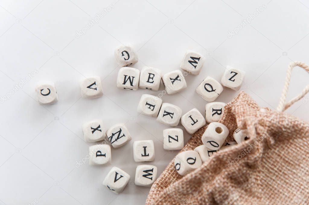 letters on dices near sack on white background 