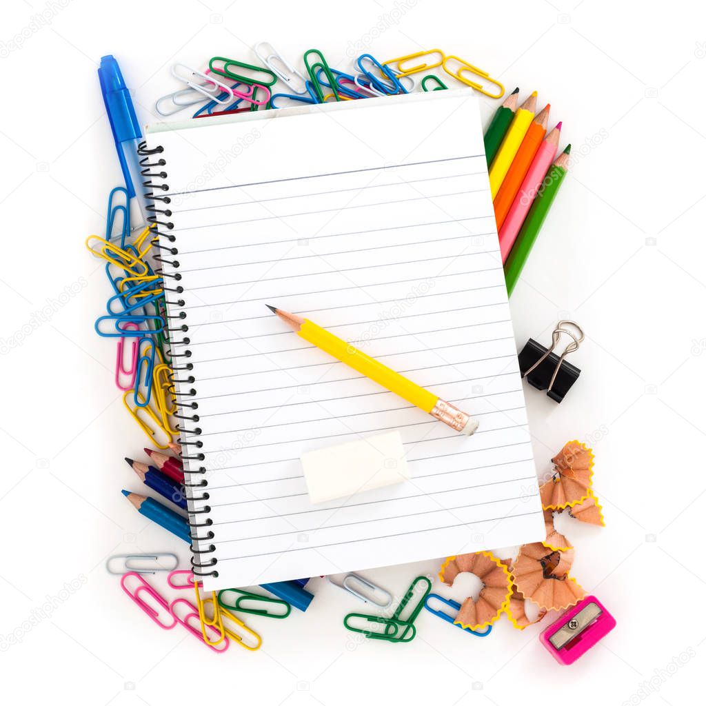 Notebook with pencil and eraser lying on colorful school supplies on white background 