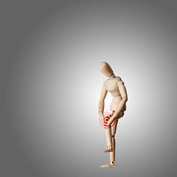 Wooden Mannequin with ache in knee joint