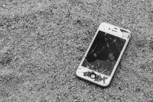 crashed smartphone on asphalt background