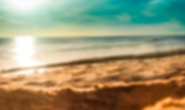 夕日を背景にぼやけ砂浜海岸 — ストック写真