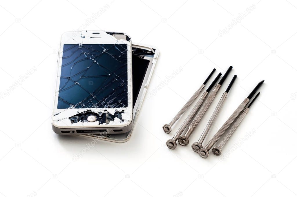 crashed smartphone with screwdrivers on white background