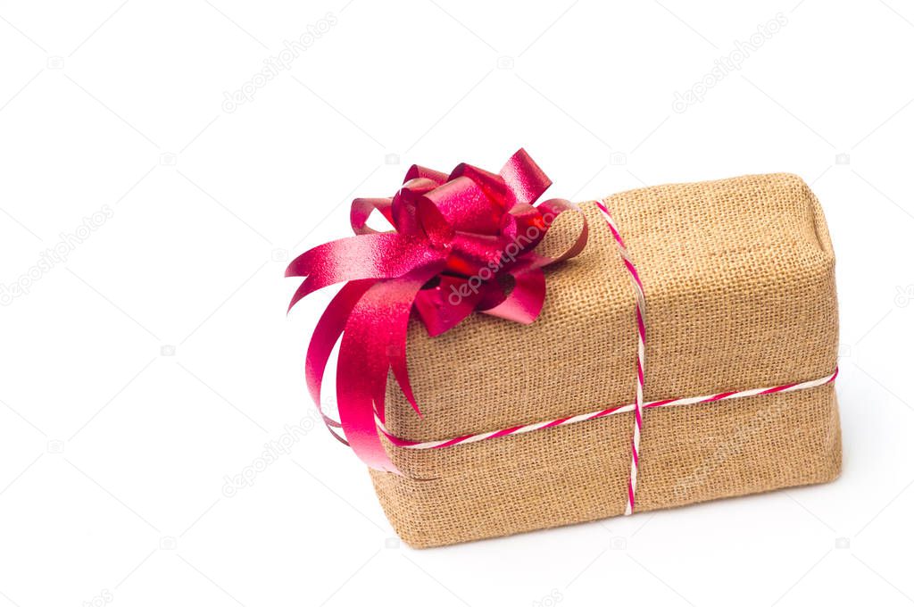Present box wrapped in sackcloth with colorful ribbon isolated on white background