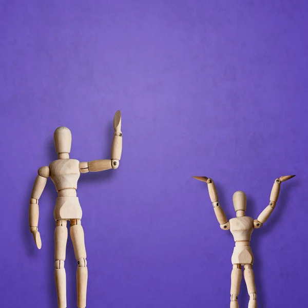 Wooden Mannequins posing on violet background