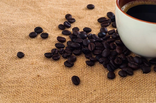 Nahaufnahme Der Tasse Mit Kaffee Und Schwarzen Bohnen Auf Sacktuch — Stockfoto