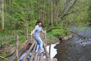 Korku ile kadın turist Nehri kırmızı ahşap köprü yüklenir. Kaliningrad bölgesi
