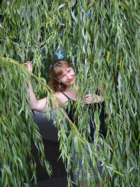 The woman of average years costs among willow branches