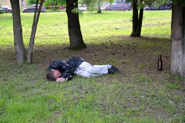 Rybinsk, Rusya Federasyonu - 22 Mayıs 2018: Sarhoş adam parkta bir çimenlikte kişi sayısı