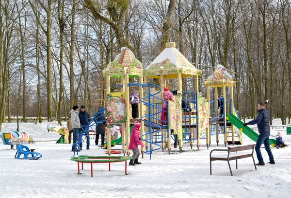 大人は冬公園の遊び場で子供たちと遊ぶ Kaliningra — ストック写真