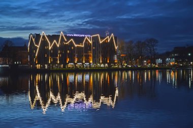 Kaliningrad, Rusya - 31 Aralık 2018: Bina Mercure otel su yansıması dekoratif aydınlatma ile. En iyi Gölü