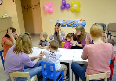 Kaliningrad, Rusya Federasyonu - 17 Nisan 2014: Öğretmen çocuklara ve ailelerine bir masada oturuyor, ile oyun sınıfları verir. Studio geliştirme yaratıcı