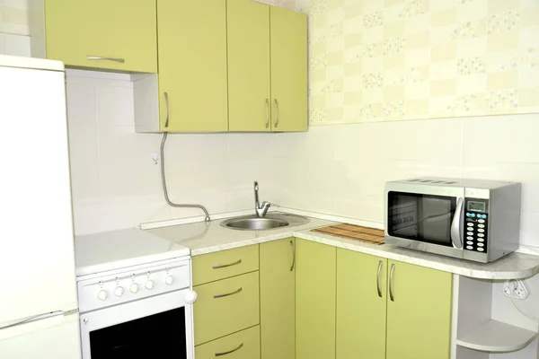 Fragment of an interior of kitchen with the gas stove and the microwave oven — Stock Photo, Image