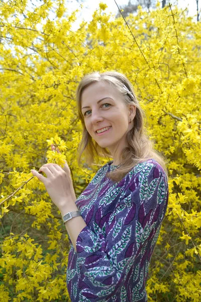 Radostná mladá žena na pozadí rozkvetlé rozkvětu. Portréty — Stock fotografie
