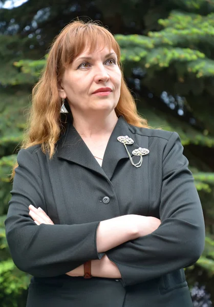 Портрет зрілої жінки в чорній куртці з схрещеними руками — стокове фото