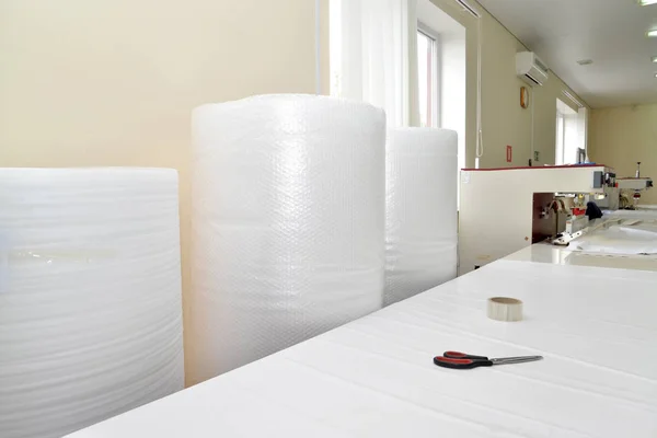 Rolls of an air and bubble film stand in the shop on production of stretch ceilings — Stock Photo, Image