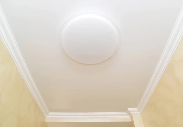 A lâmpada de teto em um teto elástico opaco em um corredor de apartamento — Fotografia de Stock
