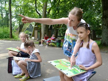 Kaliningrad, Rusya, 13 Haziran 2019: Öğretmen kıza bir manzara çizmeyi öğretiyor. Parkta bir çocuk açık havası