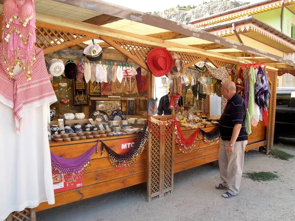 BAKHCHISARAI, CRIMEA - SETEMBRO 08, 2011: Turista escolhe lembranças no mercado — Fotografia de Stock
