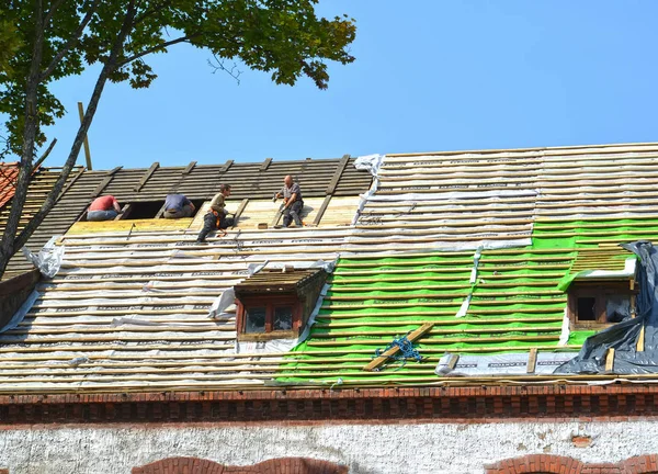 REGIÃO DE KALININGRAD, RÚSSIA - 16 DE AGOSTO DE 2019: Os construtores reparam o telhado de um antigo edifício de apartamentos construído na Alemanha — Fotografia de Stock