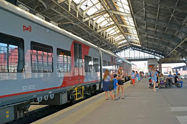 Kaliningrad, Ryssland-27 augusti 2019: människor står nära ett elektriskt tåg på södra station plattform — Stockfoto