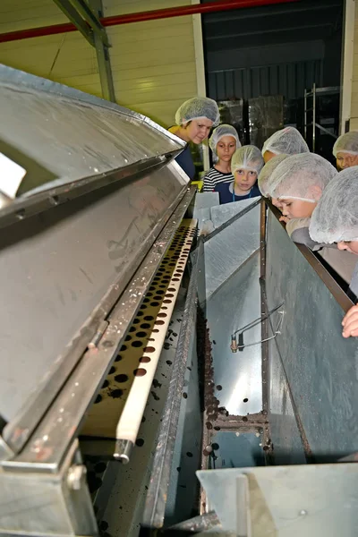 Kaliningrad, russland - 27. September 2019: Kinder beobachten die Herstellung von Kieselschokolade. Kinderführung zur Schokoladenfabrik belgostar — Stockfoto