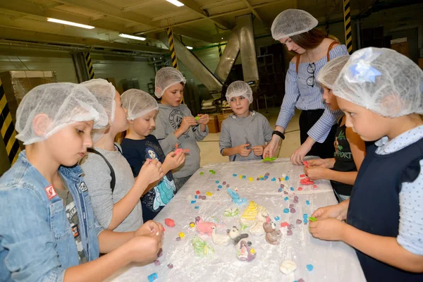 KALINININGRAD, RÚSSIA - 27 de setembro de 2019: Crianças e adultos lançam figuras de mástiques de confeitaria. Master class infantil na fábrica de chocolate — Fotografia de Stock