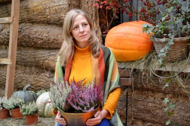 Portakal kabağının arka planında peçesi olan bir kadının portresi.