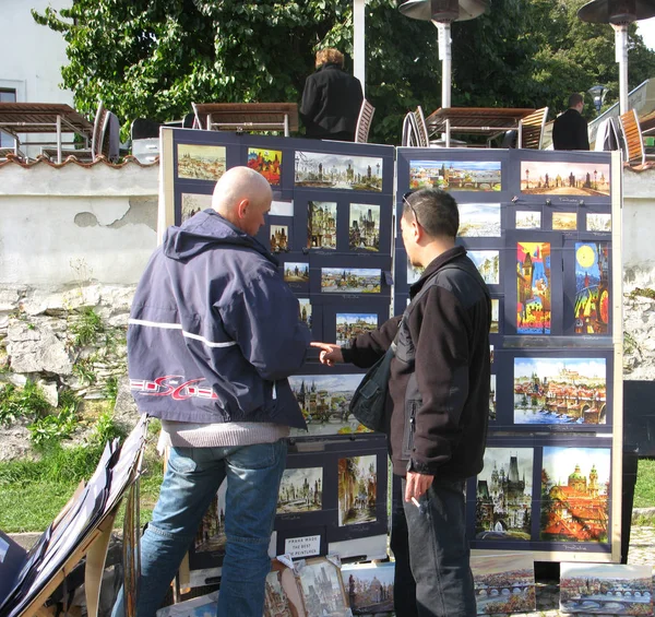 PRAGUE, CZECH REPUBLIC - SEPTEMBER 04, 2007: Artist sells his works in Prague Grad — Stock Photo, Image