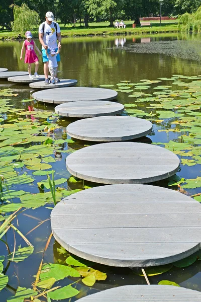 Zelenogradsk ロシア 2020年6月25日 家族は水の上の装飾的な道を歩いています 都市公園のトーティリン池 カリーニングラード地方 — ストック写真