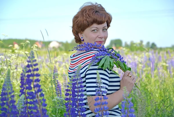 Žena Středního Věku Drží Ruce Kytici Rozkvetlých Lupinů — Stock fotografie