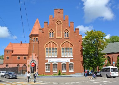 BALTIYSK, RUSSIA - 23 Temmuz 2020: Bir adam hava platformunda dururken bir lamba direğini boyar