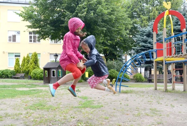 Two Sisters Jump Holding Hands Playground — Stock Photo, Image