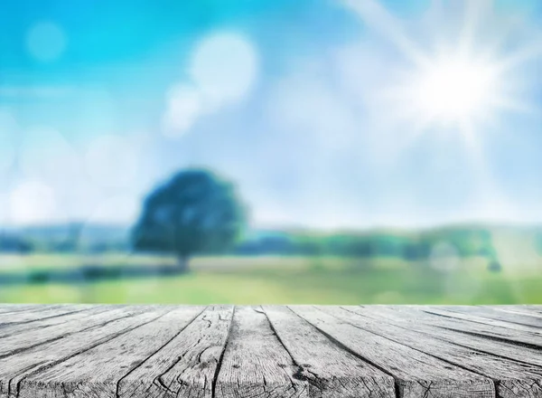 Houten tafel en voorjaar achtergrond wazig — Stockfoto