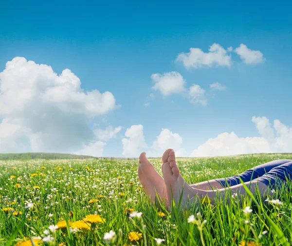 Pies desnudos en la hierba de primavera y flores — Foto de Stock