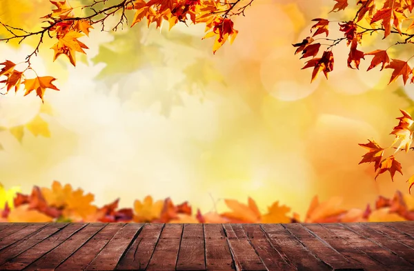 Holztisch mit orangefarbenen Herbstblättern — Stockfoto