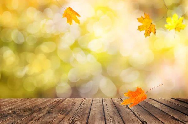 Tavolo in legno con foglie d'arancio fondo autunno — Foto Stock