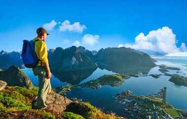 Adam gün batımında Norveç 'te yürüyüş yapıyor.
