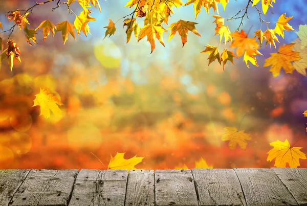 オレンジの葉を持つ木製のテーブル秋の背景 — ストック写真