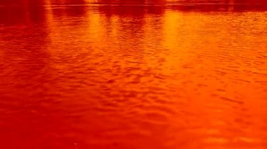 Sudaki dalgalanmalar, rüzgar. Parlak turuncu, sarı ve kırmızı renkler. Dinamik video alt katmanı, ekran koruyucu. Meditative video çizim. Video klip resmi.
