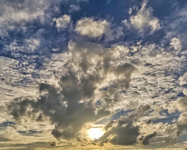 Ήλιος Πίσω Από Σύννεφα Μπλε Ουρανό Φόντο — Φωτογραφία Αρχείου