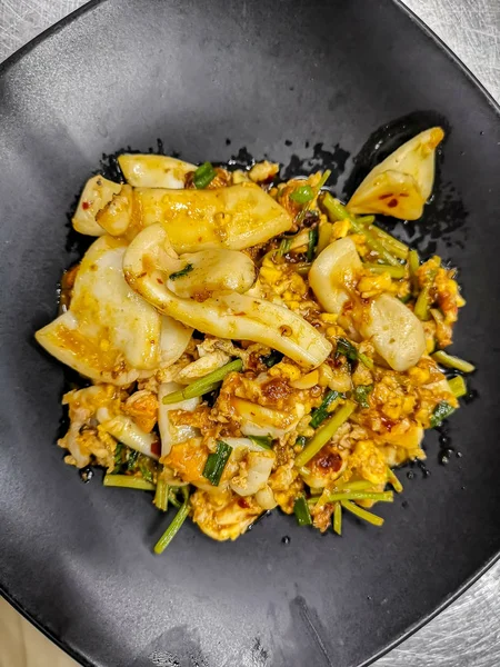 Tayland mutfağı tuzlu yumurta sarısı sos siyah çanak üzerinde squid karıştırın